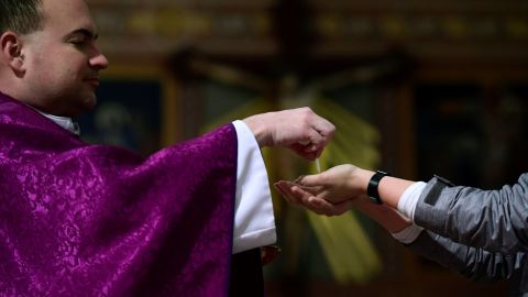 Un feligrés comulga de las manos del sacerdote Laszlo Monostori en la iglesia de Santa Margarita en Budapest, Hungría.