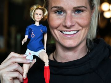 La futbolista Amandine Henry sostiene la muñeca que inspiró.