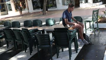 Un turista sentado en una mesa de un restaurante en la emblemática avenida de Lincoln Road en Miami Beach.