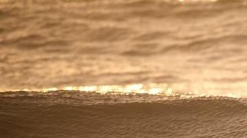 Un surfista entra al mar al atardecer. Foto de archivo.
