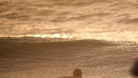 Un surfista entra al mar al atardecer. Foto de archivo.