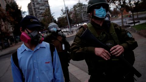 Un manifestante observa a un policía  durante las protestas contra el Gobierno de Sebastián Piñera.