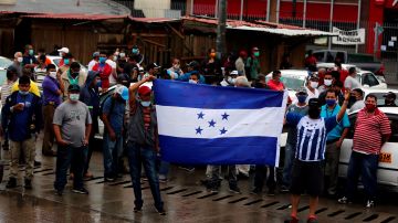 -FOTODELDIA- AME2487. TEGUCIGALPA (HONDURAS), 27/05/2020.- Trabajadores de transporte público cierran el paso en una calle durante una protesta este miércoles, en Tegucigalpa (Honduras). El transporte público de Honduras prevé manifestaciones en al menos las dos principales ciudades, Tegucigalpa y San Pedro Sula, para exigir al Gobierno que se les permita regresar a sus actividades, paralizadas desde marzo a causa de la pandemia de COVID-19. El domingo, el Gobierno extendió hasta el 31 de mayo la alerta roja y el toque de queda que rige desde mediados de marzo. EFE/Gustavo Amador