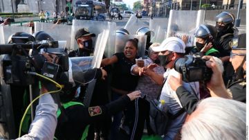 Policías de Ciudad de México intentan retirar a los manifestantes que cobraban peaje a motociclistas.