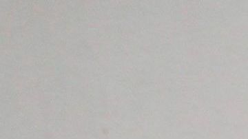 Una joven camina frente a un letrero que indica que el uso de la máscara es obligatorio en el transporte público en Sao Paulo.