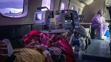 Personal médico trabaja al interior de un avión ambulancia con pacientes contagiados con COVID-19, en Manaos.