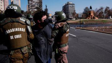 A protester is detained by the Carabineros Special Forces this Friday during a small rally in Plaza Italia in Santiago, Chile 1 May 2020, during a small gathering on the occasion of the celebration of International Workers' Day. EFE/Alberto Valdes