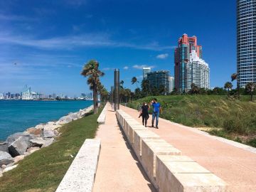 Una pareja camina en el parque South Pointe en Miami Beach.