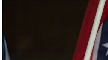 Un supremacista hace el saludo nazi con una bandera de la confederación y las cruces símbolo del Ku Klux Klan.