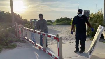 Empleados de la ciudad despejaban los accesos a la playa de Miami Beach para que los residentes y turistas puedan volver a entrar.