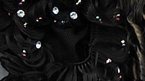 Una mujer ayuda a otra a chequear una extensión de cabello en un mercado.