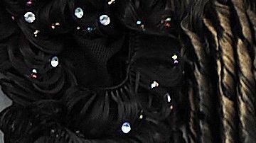 Una mujer ayuda a otra a chequear una extensión de cabello en un mercado.