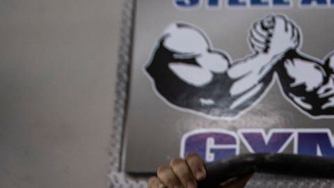 Un hombre haciendo ejercicio en un gimnasio con mascarilla.