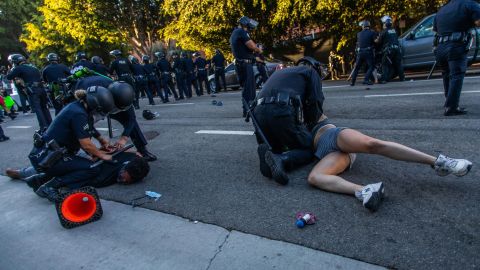 La policía arrojó contra el suelo a un hombre y a una mujer.