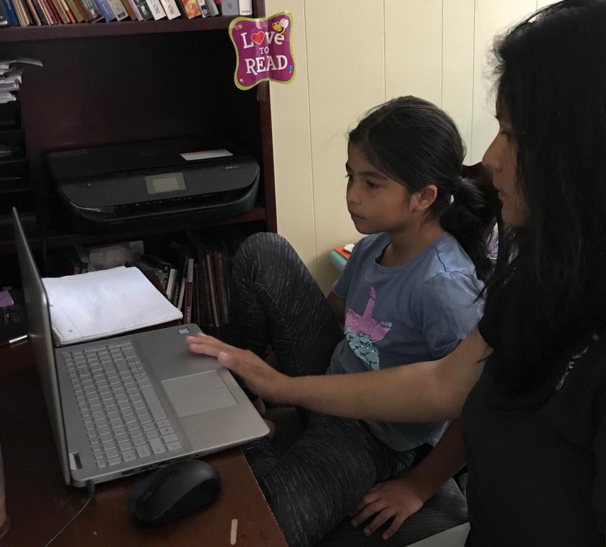 Vannesa López ayuda en sus clases remotas a su hija, estudiante de la primaria Orozco Community Academy. (Cortesía familia López a La Raza)