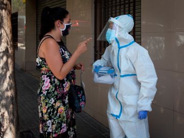 Un trabajador de la salud habla con una mujer en Barcelona.