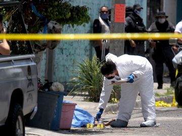 MEXICO-CRIME-VIOLENCE
EDITORS NOTE: Graphic content / A forensic expert works next to a corpse after an armed group attacked two houses killing nine people and leaving one wounded, at the Lopez Portillo neighborhood in Guadalajara, Jalisco state, Mexico on May 3, 2020. (Photo by ULISES RUIZ / AFP) / GRAPHIC CONTENT (Photo by ULISES RUIZ/AFP via Getty Images)