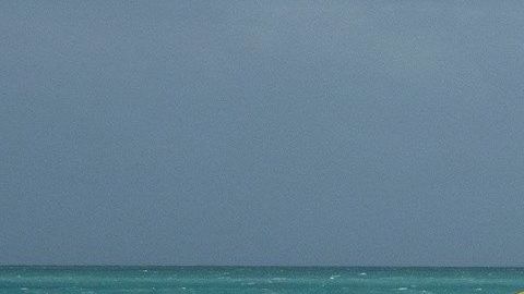 People enjoy the waves on the closed beach in Miami beach, Florida, USA, 01 August 2020. Hurricane Isaias weakened and lost intensity after passing over the Bahamas and it still on course to arrive off the coast of Florida Saturday night, according to the National Hurricane Center.
