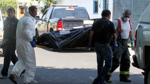 MEXICO-CRIME-CORPSES
Forensic personnel carry one of the corps found at the crime scene of a clandestine grave located inside a house in Guadalajara, Jalisco State, Mexico on August 3, 2018. - The prosecutor´s office of the state of Jalisco reported at least ten bodies have been found in a clandestine grave, Guadalajara is the second Mexican city and has a strong presence of organised crime. (Photo by ULISES RUIZ / AFP)        (Photo credit should read ULISES RUIZ/AFP via Getty Images)