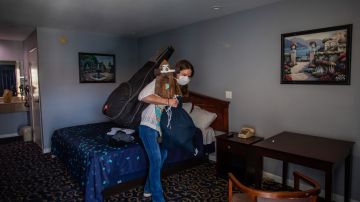 Una mujer sin hogar en una habitación de hotel del proyecto Roomkey de California.