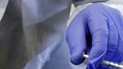 Una vacuna contra el covid-19 es aplicada a un paciente.