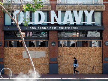 Una persona pasa por una tienda minorista de Old Navy cerrada en San Francisco, California.