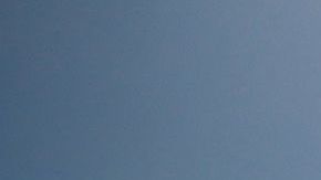 Una mujer pasando con una bicicleta frenta a un cartel de "playa cerrada" en South Beach, en Miami Beach.