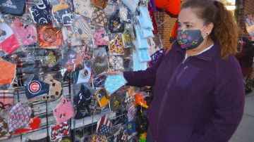 Marisela González compra mascarillas a una vendedora ambulante en el barrio de Back of The Yards. (Belhú Sanabria / La Raza)