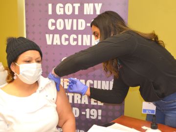 María Lucía Díaz recibe la primera dosis de la vacuna covid-19 en el Centro Médico Alivio en Pilsen. (Belhú Sanabria / La Raza)