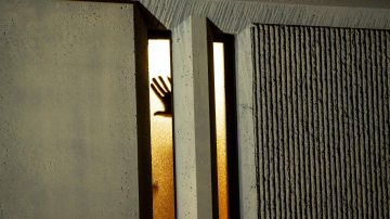 Una persona coloca su mano en una ventana dentro de una cárcel el 24 de enero de 2021 en Tacoma, Washington.