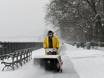 Un hombre usa un soplador de nieve durante una tormenta invernal en Nueva York
