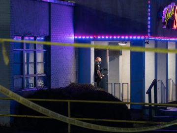 Un oficial de policía se encuentra afuera de una sala de masajes donde tres personas fueron asesinadas a tiros el 16 de marzo de 2021 en Atlanta, Georgia.