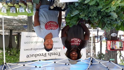 La dueña del negocio Cedillo's Fresh Produce, Dulce Morales, y un trabajador atienden a los clientes que buscan productos orgánicos en el Mercado de Colores de La Villita.  (Belhú Sanabria / La Raza)