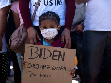 Una pequeña niña pide, en marzo de 2021, al presidente Joe Biden le permita entrar a Estados Unidos para seguir allí su caso de asilo sin tener que esperar en México. (Getty Images)