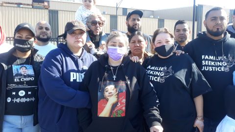 María Vega con mascarilla color púrpura y con una playera que lleva estampada la imagen de su hijo junto a familiares y amigos en una vigilia en el estacionamiento del supermercado Jewel-Osco en South Loop, el sábado 16 de octubre. Foto Belhú Sanabria/La Raza