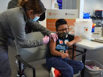Nancy Rojas llevó a su hijo Erick Rojas, de 7 años, a recibir la vacuna covid-19 de Pfizer. (Belhú Sanabria / La Raza)