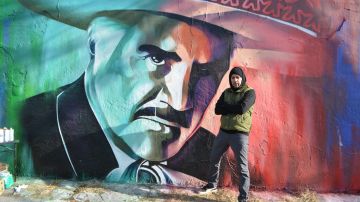 El mural de Vicente Fernández y su creador, el artista Milton Coronado, en el barrio Logan Square. (Belhú Sanabria / La Raza)