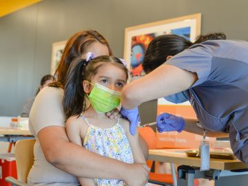 Niños latinos menores de cinco años acompañados de sus padres reciben la vacuna contra el covid-19 en Esperanza Health Centers. (Cortesía Esperanza Health Centers)