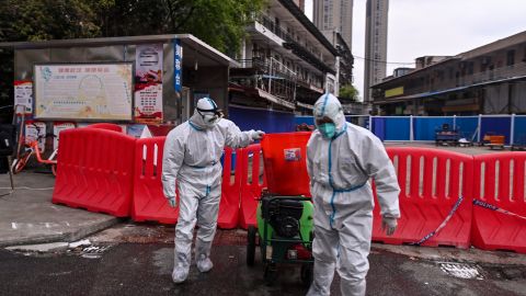 Trabajadores con trajes protectores en el mercado de mariscos de Wuhan, China, ciudad en donde se reportaron los primeros casos registrados de covid-19.