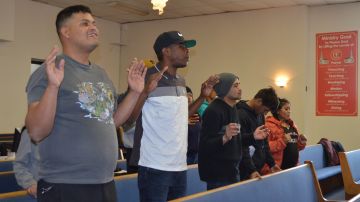 Migrantes que se refugian de manera temporal en la antigua escuela primaria Wadsworth asisten al servicio religioso en la Iglesia Concord Missionary Baptist en el área de Woodlawn. (Belhú Sanabria / La Raza)