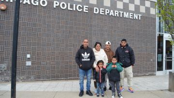 Los migrantes Leonel González, su esposa Amparo Cubides, sus hijos y dos nietos, de 5 y 8 años, en la estación de policía del Distrito 20. (Belhú Sanabria / La Raza)