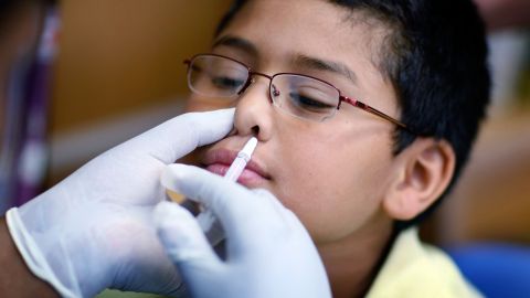 Un niño recibe la vacuna nasal FluMist contra la influenza/gripe.