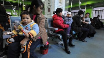 Niños acompañados de sus padres esperan ser atendidos en un hospital en China.