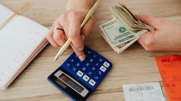 woman calculating money and receipts using a calculator